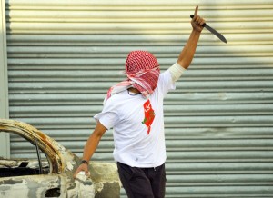 A Palestinian demonstrator raises a knife, during clashes with Israeli police, in Shuafat refugee camp in Jerusalem, Friday, Oct. 9, 2015. Recent days have seen a string of attacks by young Palestinians with no known links to armed groups who have targeted Israeli soldiers and civilians at random, complicating Israeli efforts to contain the violence, which has been linked to tensions over a sensitive Jerusalem holy site. (AP Photo/Mahmoud Illean)